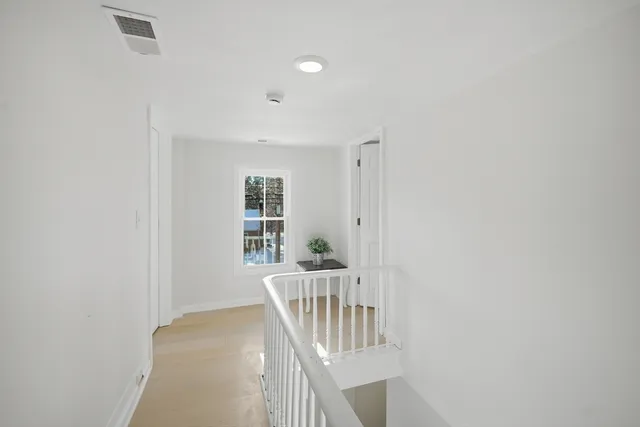 a view of a hallway with wooden floor and entryway