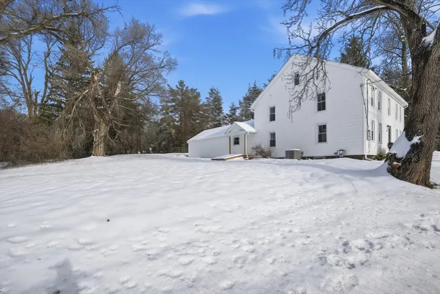 a view of white house with a snow in the yard