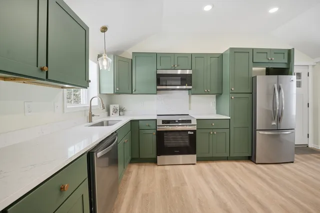 a kitchen with stainless steel appliances granite countertop a refrigerator stove and sink