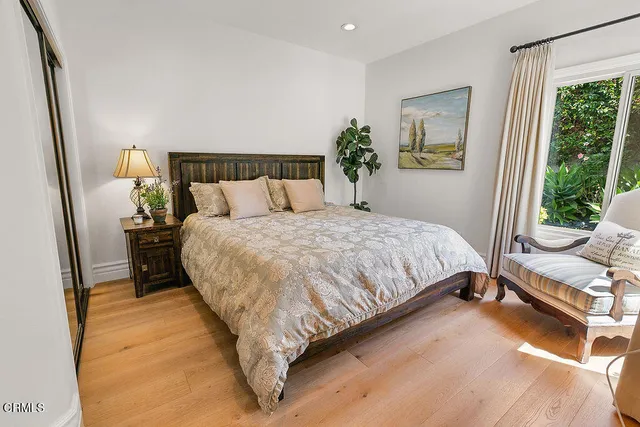a bedroom with a bed and a flat tv screen on dresser