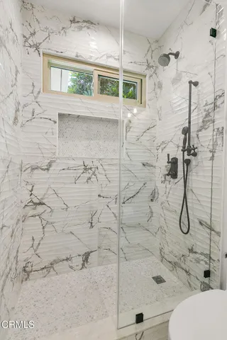 a bedroom with a bed and a dresser next to a window