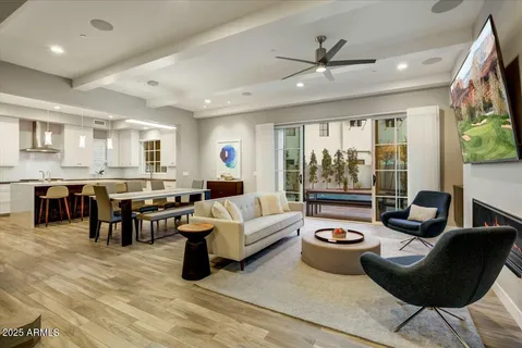 a living room with furniture kitchen area and a large window