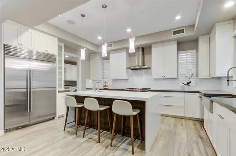 a kitchen with stainless steel appliances granite countertop a table chairs sink and cabinets