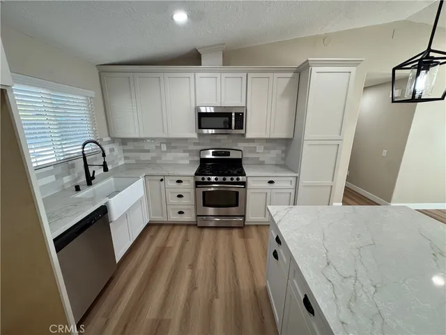a kitchen with white cabinets sink and stainless steel appliances