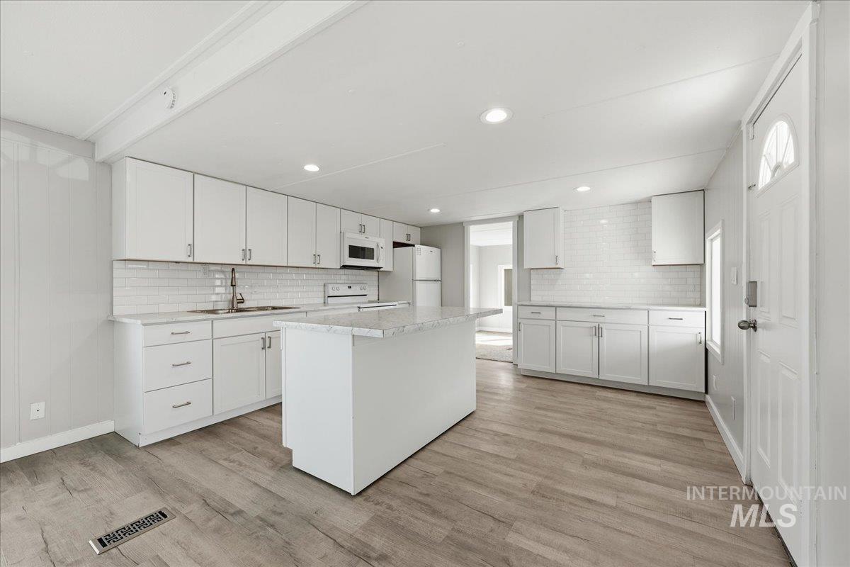 5015 East Ustick Road, Unit 172 Caldwell, ID 83605 - Photo 5 of 21 Kitchen featuring white cabinets, a center island, white appliances, backsplash, and recessed lighting