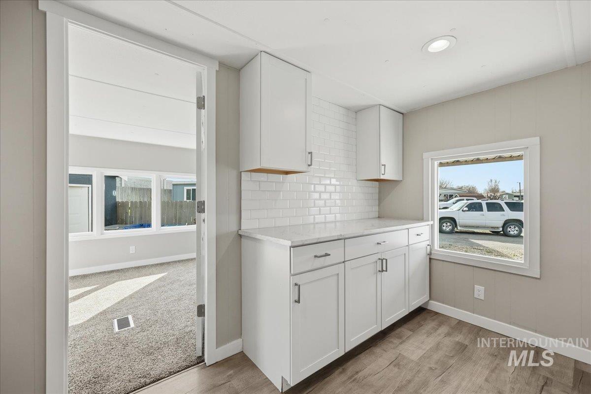 5015 East Ustick Road, Unit 172 Caldwell, ID 83605 - Photo 8 of 21 Kitchen with white cabinetry, tasteful backsplash, light wood-type flooring, light stone counters, and recessed lighting