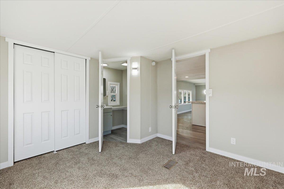 5015 East Ustick Road, Unit 172 Caldwell, ID 83605 - Photo 10 of 21 Unfurnished bedroom featuring light colored carpet, a closet, and connected bathroom