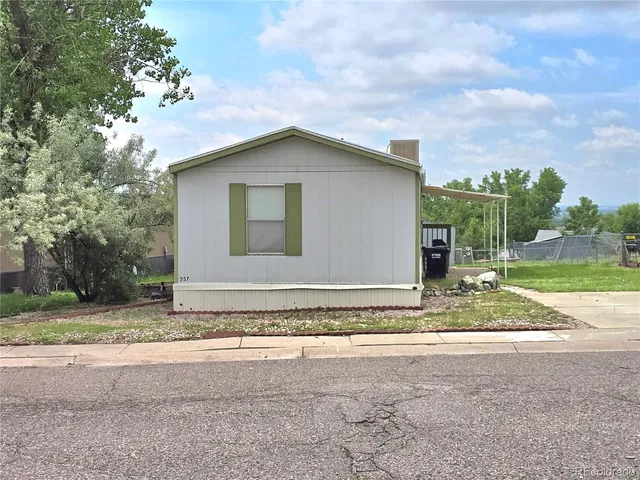 a view of a house with a yard and large tree