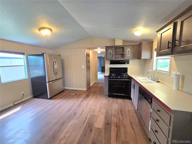 a kitchen with stainless steel appliances a refrigerator and a stove top oven
