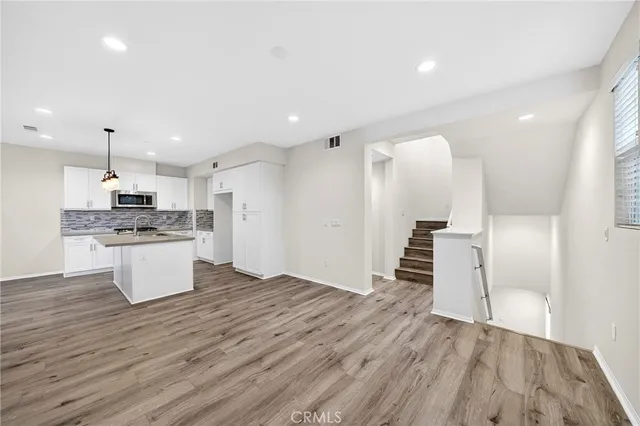 an open kitchen with white cabinets and stainless steel appliances