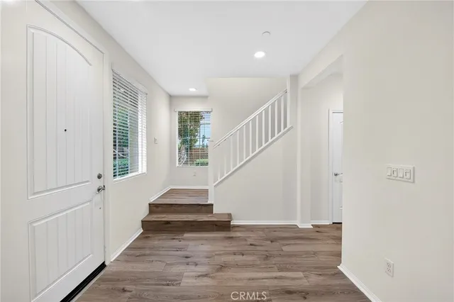 a view of entryway and hall with wooden floor