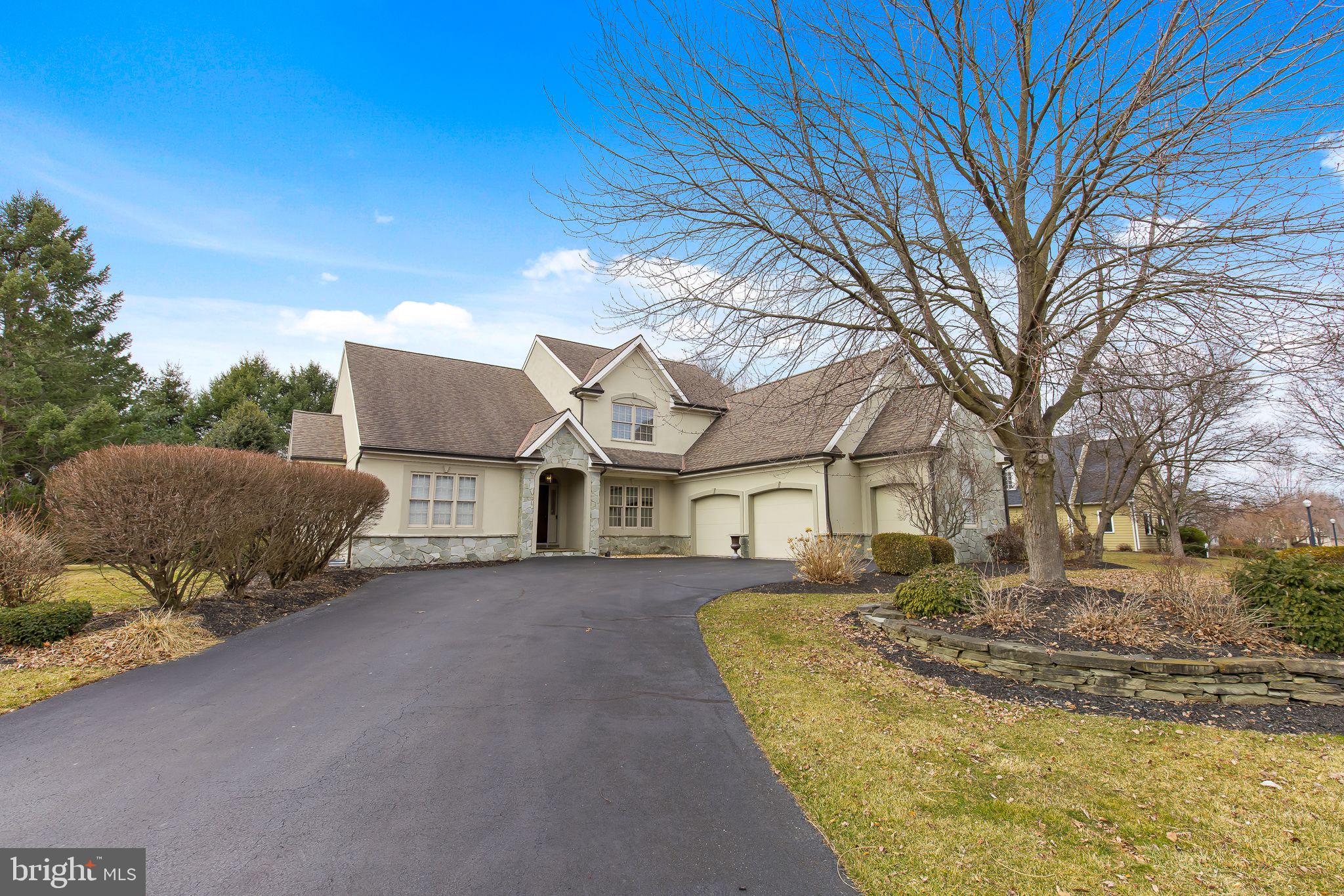 a view of a house with a large tree in front of it