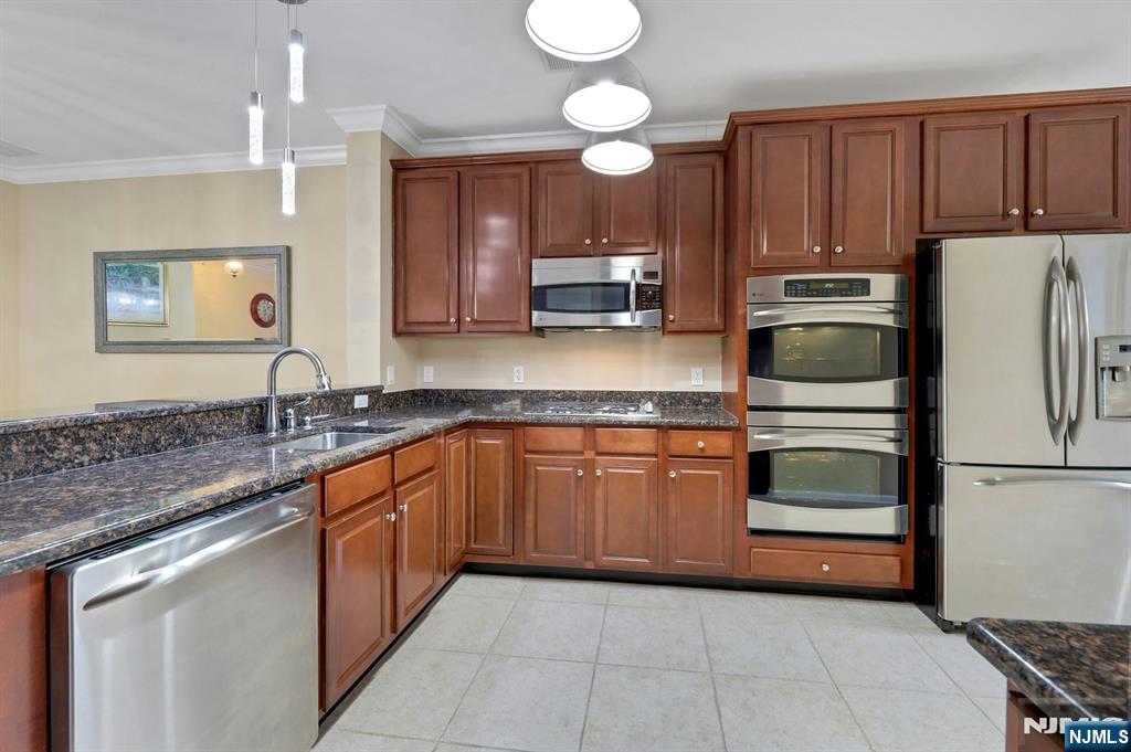 6 Cliff Road, Unit D2 Woodland Park, NJ 07424 - Photo 11 of 40 a kitchen with stainless steel appliances granite countertop a sink stove and refrigerator