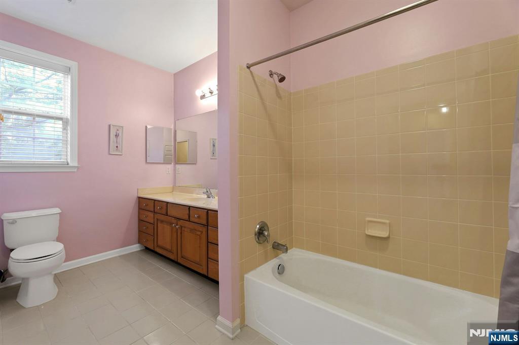 6 Cliff Road, Unit D2 Woodland Park, NJ 07424 - Photo 22 of 40 a bathroom with a granite countertop toilet a sink and bathtub