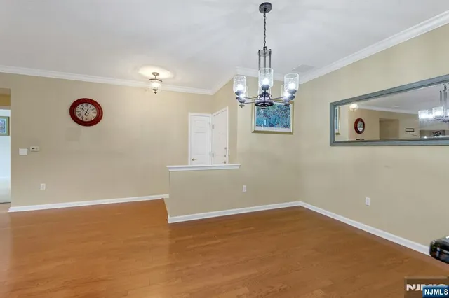 a view of a livingroom with a chandelier fan and kitchen view
