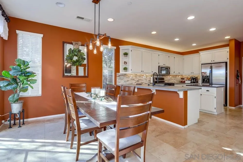 10005 Day Creek Trail Santee, CA 92071 - Photo 17 of 45 a open kitchen with stainless steel appliances granite countertop a refrigerator a stove a sink a dining table and chairs with wooden floor