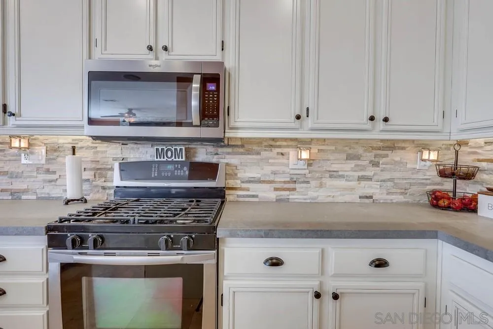 10005 Day Creek Trail Santee, CA 92071 - Photo 22 of 45 a kitchen with granite countertop white cabinets and white appliances