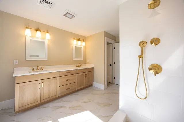 a bathroom with a double sink shower and a mirror
