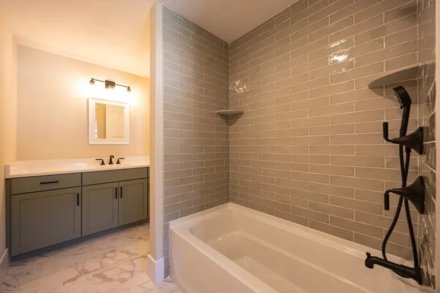 a bathroom with a granite countertop sink a toilet and bathtub