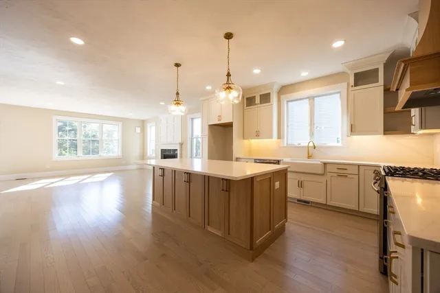 a large kitchen with kitchen island white cabinets and wooden floor