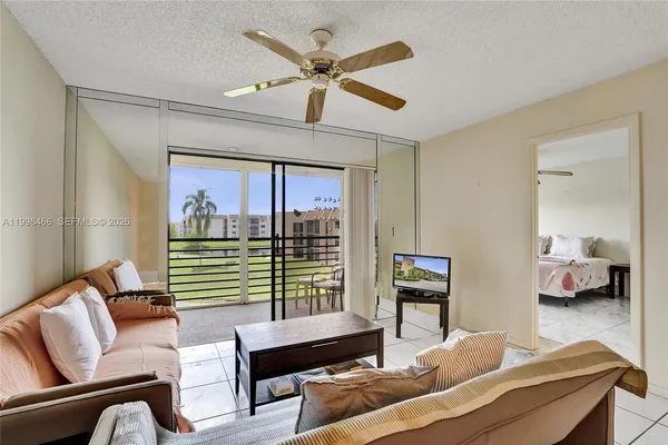 a living room with furniture and a large window with garden view