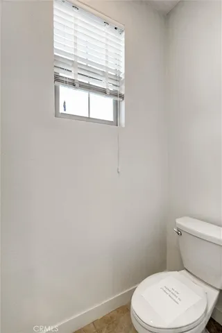 a white toilet sitting next to a window
