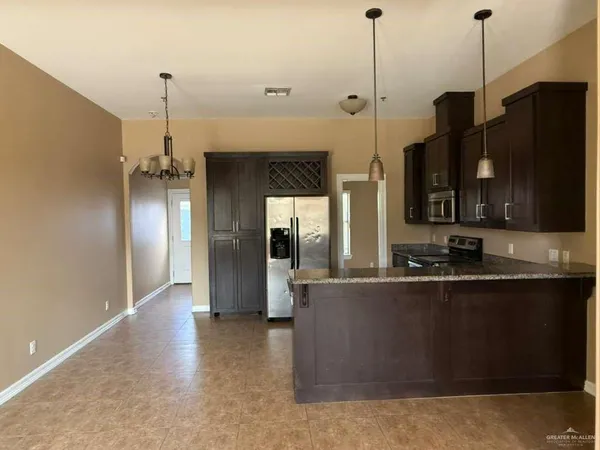 a kitchen with stainless steel appliances granite countertop a refrigerator a sink and a stove