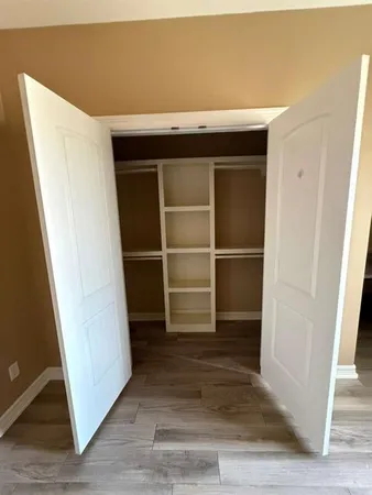 a view of walk in closet with empty racks