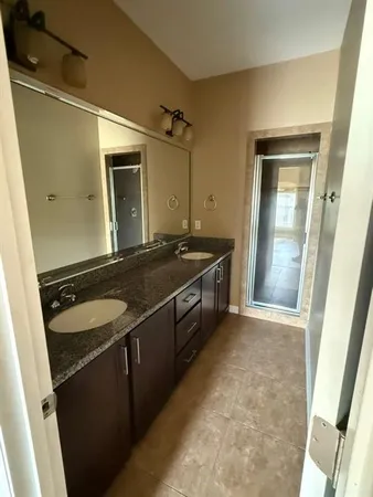 a bathroom with a granite countertop sink and a mirror
