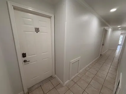 an empty room with wooden floor and a ceiling fan