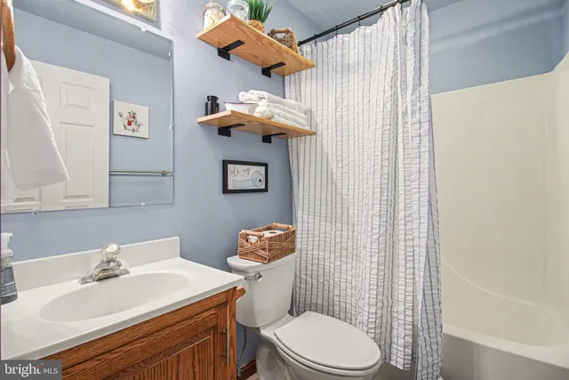 a bathroom with a sink a toilet and shower curtain