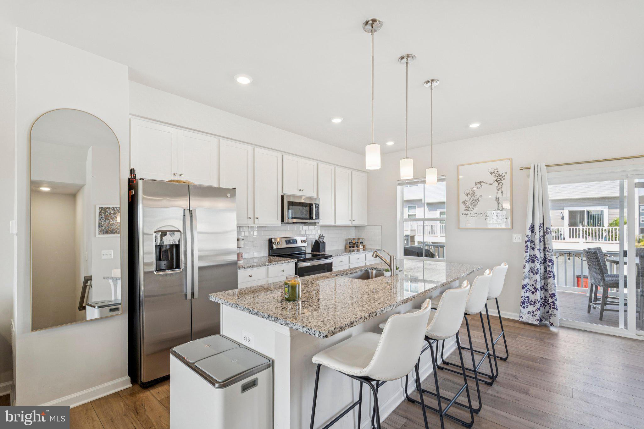 79 Swan Fld Avenue Ranson, WV 25438 - Photo 5 of 22 a kitchen with stainless steel appliances kitchen island granite countertop a refrigerator a stove a kitchen island with a dining table and chairs
