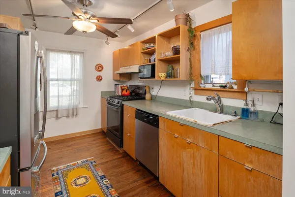 a kitchen with stainless steel appliances granite countertop a sink stove and cabinets