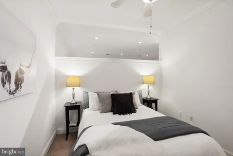 a bedroom with a bed and a lamp on the dresser