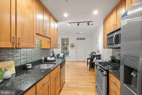 a kitchen with granite countertop stainless steel appliances and wooden cabinets