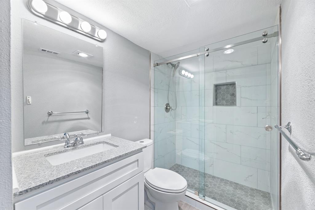 100 West Way Drive Allen, TX 75002 - Photo 22 of 31 Second Full bathroom with a marble finish shower, a textured ceiling, vanity, and a textured wall