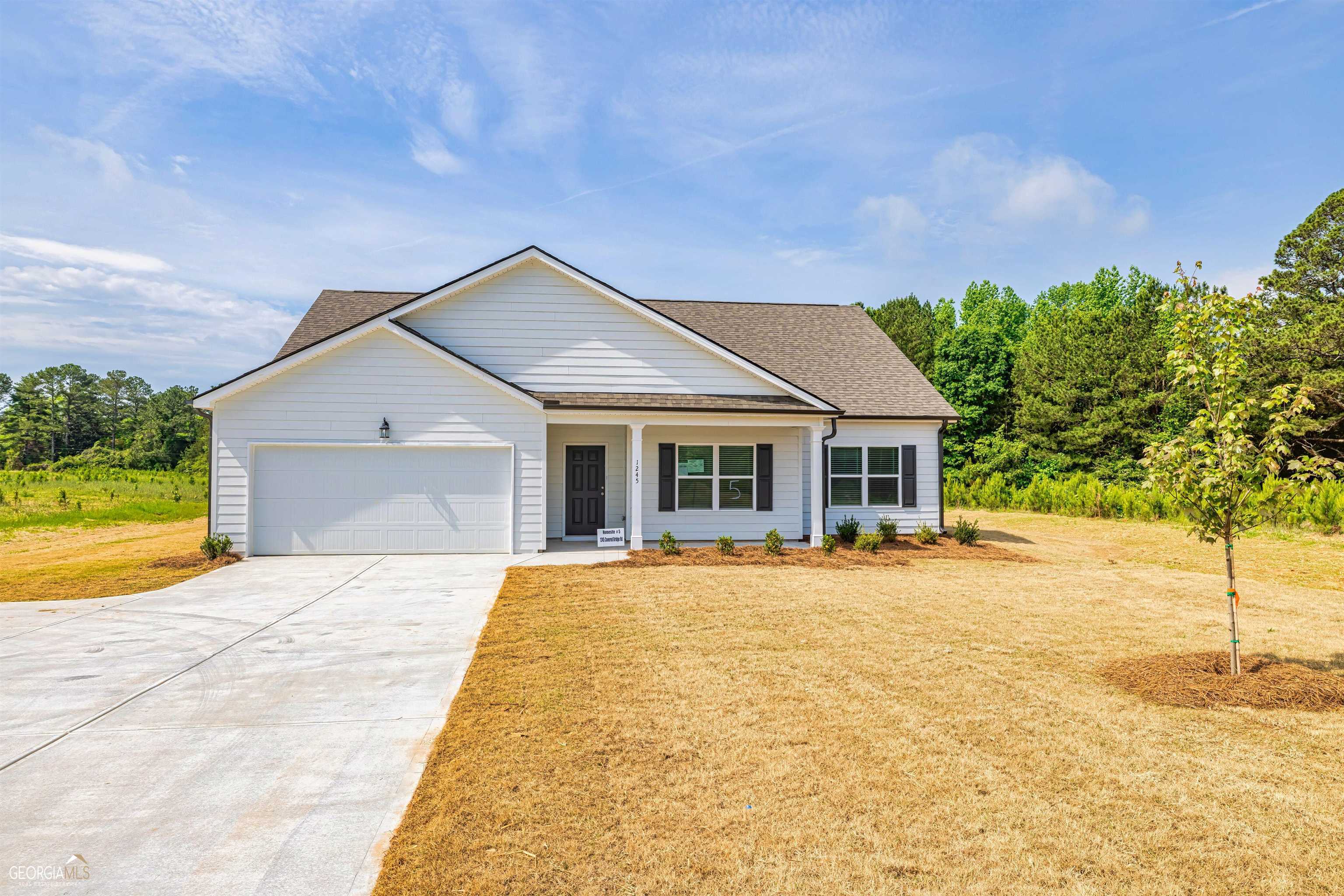 1245 Covered Bridge Road Covington, GA 30016 - Photo 1 of 1 a front view of a house with a yard and garage