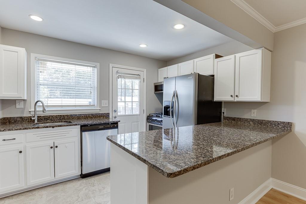 4282 Roswell Road Northeast, Unit D2 Atlanta, GA 30342 - Photo 16 of 42 a kitchen with kitchen island granite countertop a sink a center island and cabinets