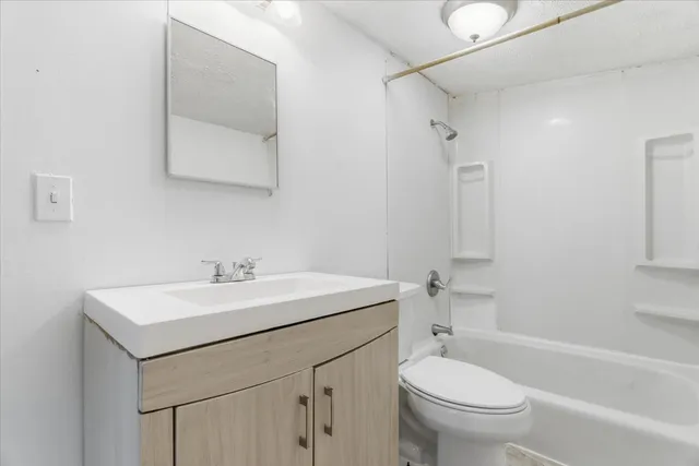 a bathroom with a sink toilet vanity and tub