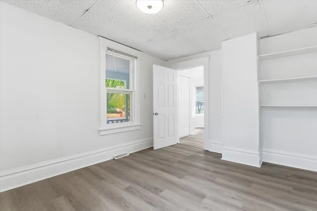 an empty room with wooden floor and window