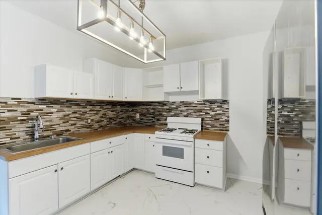 a kitchen with white cabinets and white appliances