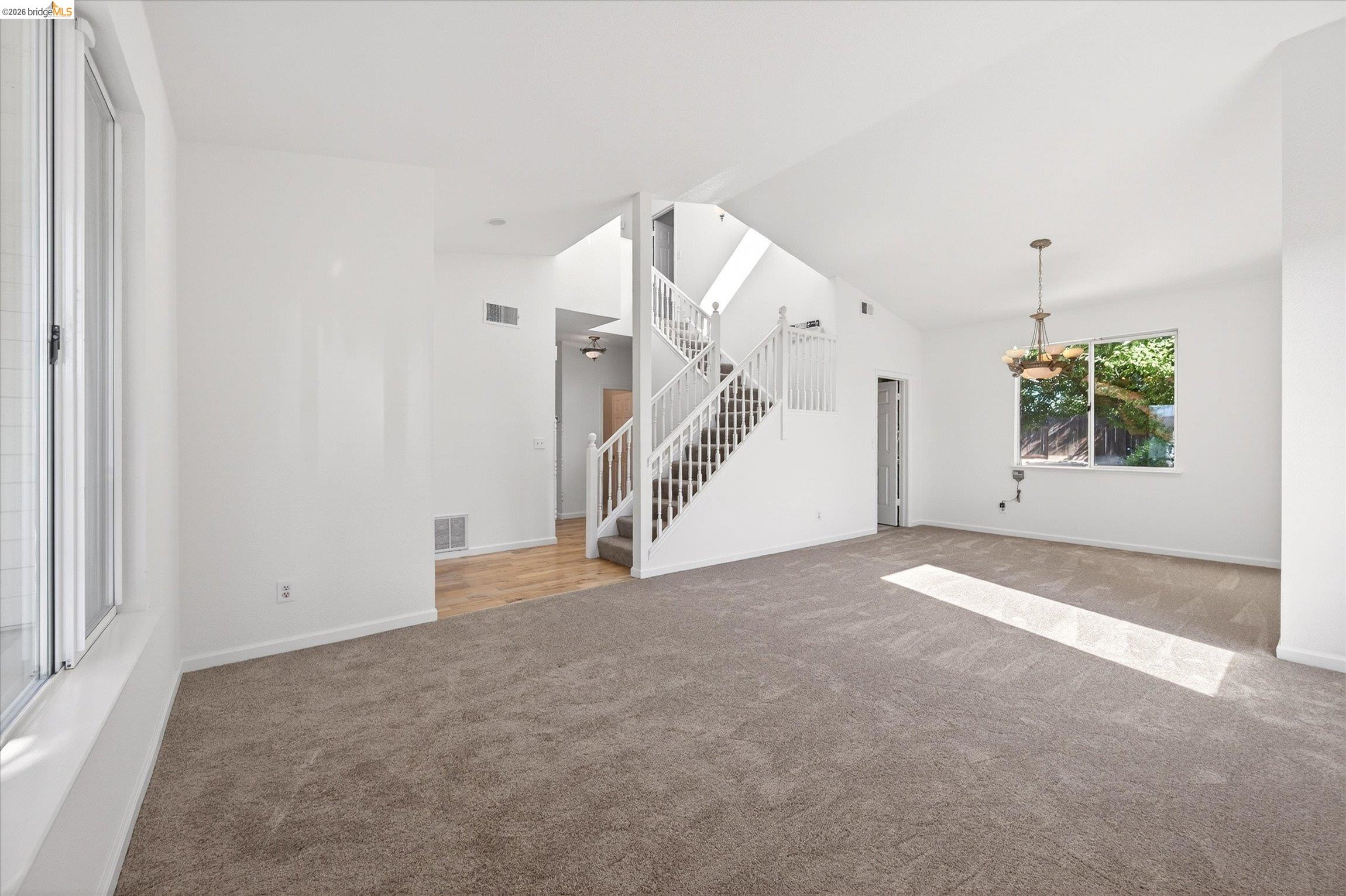 1120 Deerpark Road Oakley, CA 94561 - Photo 5 of 30 Expansive living area featuring vaulted ceilings, a staircase with white railings, and large windows