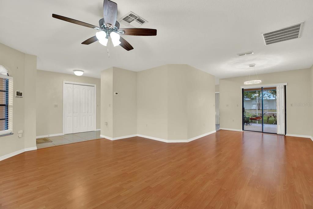 1503 Overland Drive Spring Hill, FL 34608 - Photo 6 of 24 a view of an empty room with wooden floor and a ceiling fan
