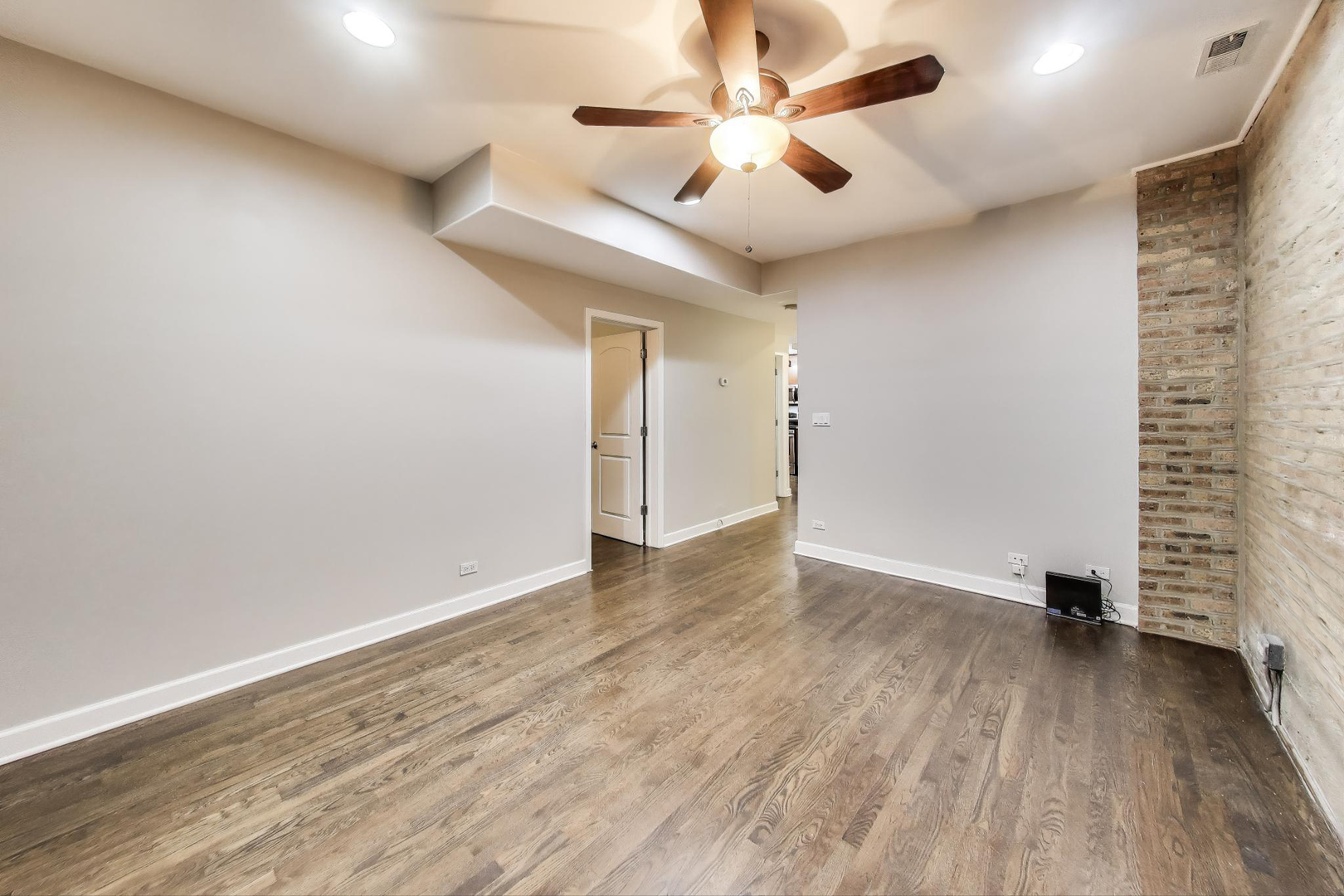 1658 West Farwell Avenue, Unit GC Chicago, IL 60626 - Photo 5 of 20 an empty room with a ceiling fan and wooden floor