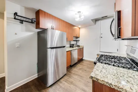 a kitchen with stainless steel appliances granite countertop a stove a sink and a refrigerator