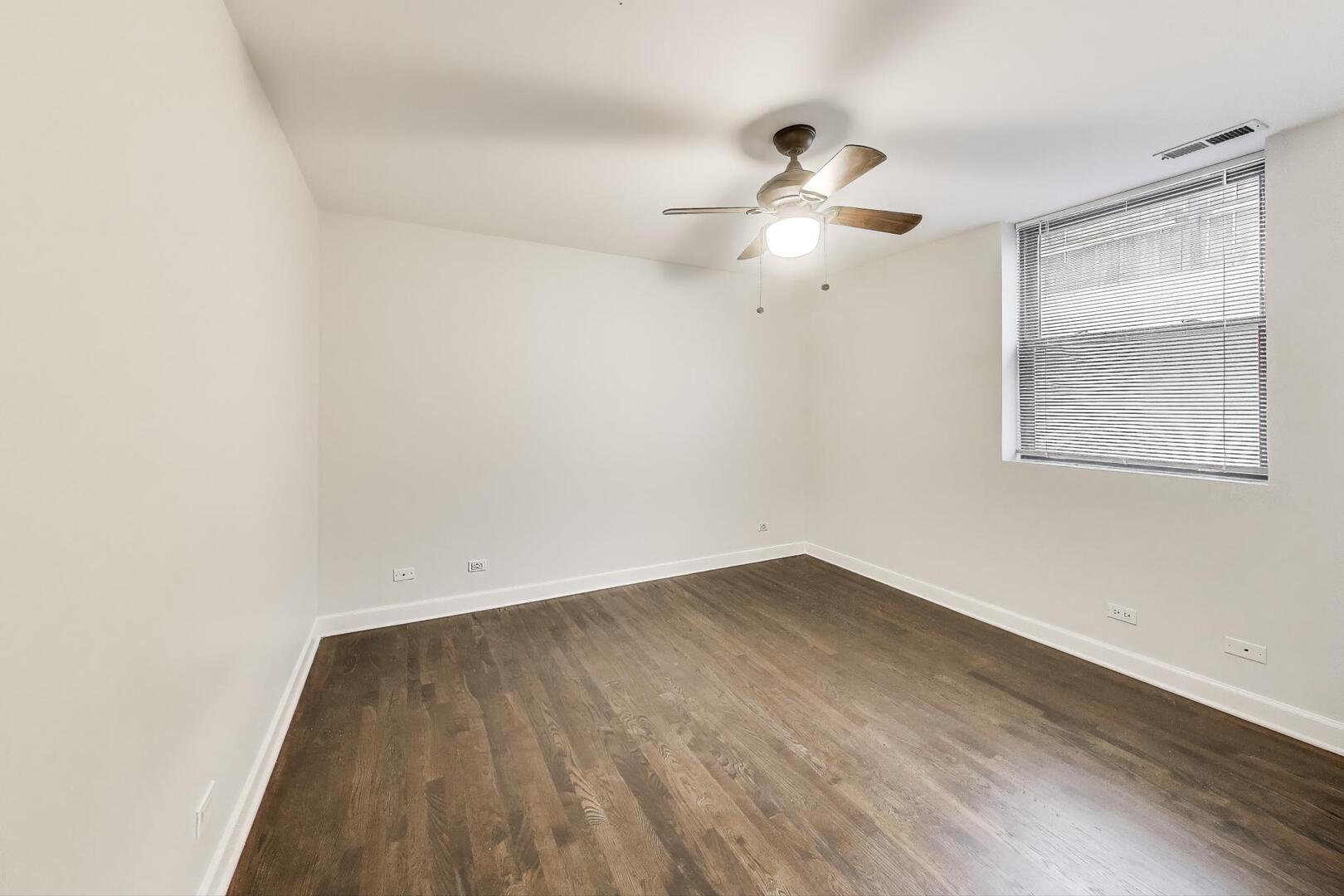 1658 West Farwell Avenue, Unit GC Chicago, IL 60626 - Photo 8 of 20 an empty room with wooden floor and fan