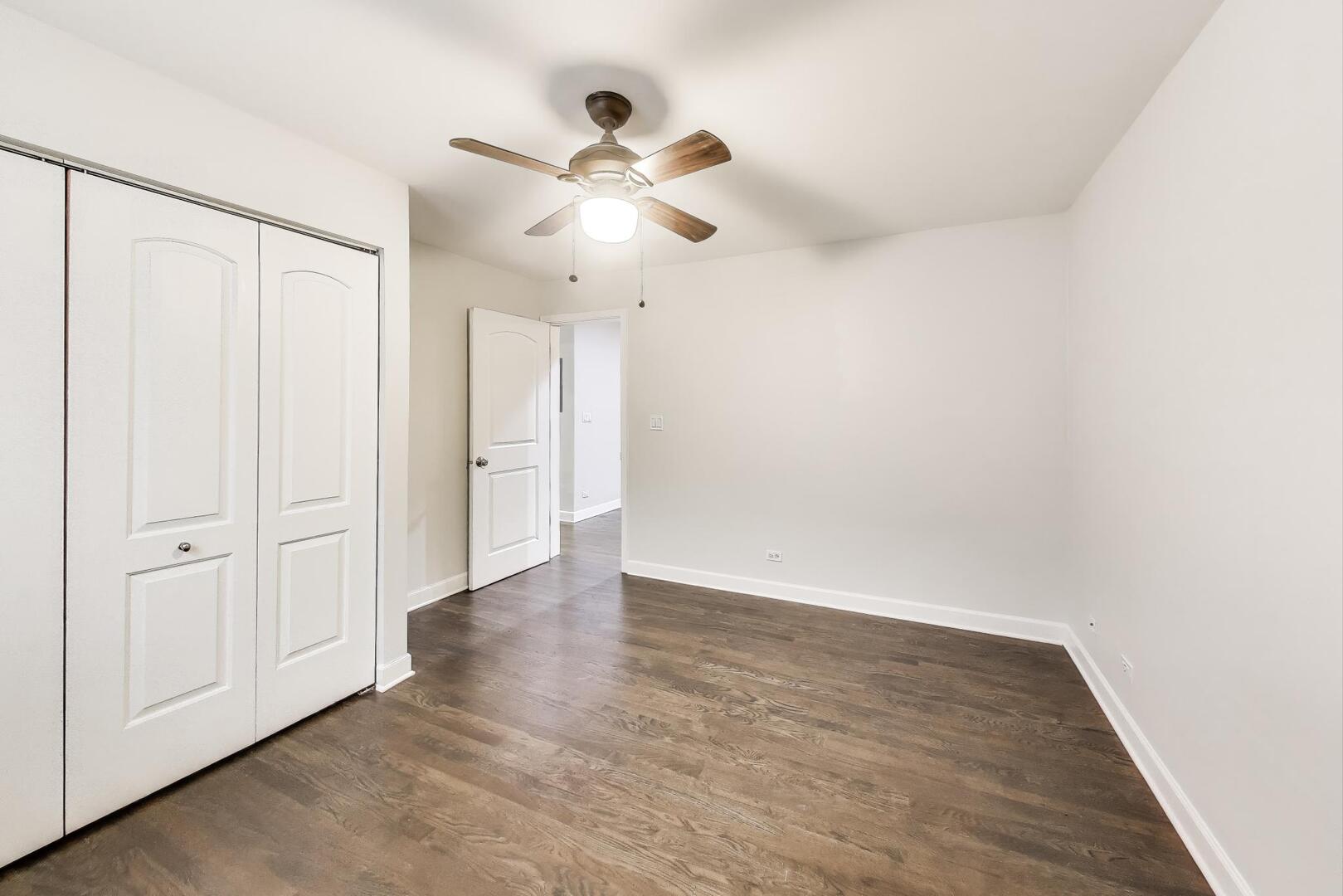 1658 West Farwell Avenue, Unit GC Chicago, IL 60626 - Photo 9 of 20 an empty room with wooden floor fan and windows