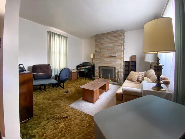 a living room with furniture fireplace and window