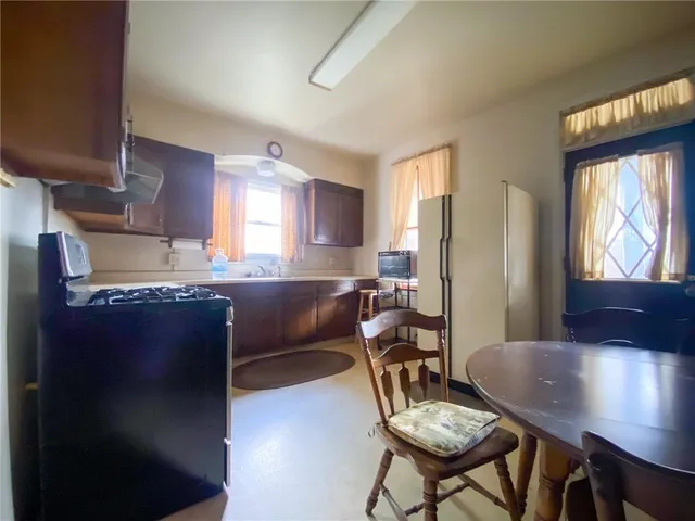 a kitchen with stainless steel appliances granite countertop a refrigerator a stove a sink dishwasher with a dining table and chair