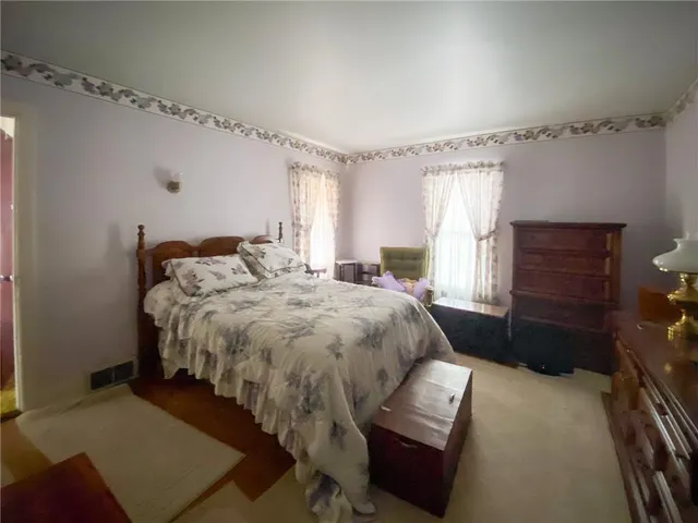 a bedroom with a bed and a dresser with the bookshelf